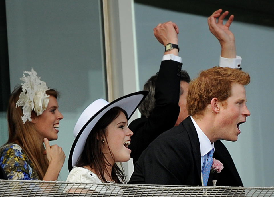 Britain's Princesses of York, Eugenie (L) and Beatrice (C) and Prince Harry cheer during the Derby on Derby Day, the second day of the Epsom Derby, in Surrey, southern England on June 4, 2011. The Queen's horse, Carlton House, ridden by Ryan Moore, was seeking to be the first Derby winner owned by a reigning monarch since Minoru won in 1909 for King Edward VII. AFP PHOTO/ BEN STANSALL (Photo credit should read BEN STANSALL/AFP/Getty Images)