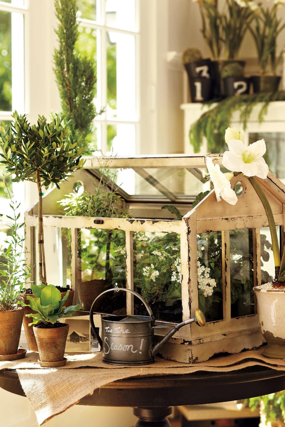 In this photo provided by Pottery Barn, this terrarium made of distressed painted pine and glass replicates early greenhouses, popular during the Victorian era. Those drawn to 19th-century style may be happy to learn that vintage garden decor is a trend for spring and summer. (AP Photo/Pottery Barn)