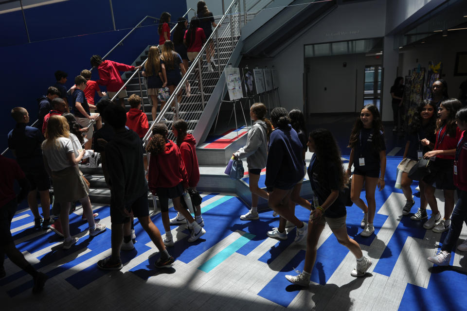 Middle school students walk between classes at A.D. Henderson School in Boca Raton, Fla., Tuesday, April 16, 2024. When teachers at the K-8 public school, one of the top-performing schools in Florida, are asked how they succeed, one answer is universal: They have autonomy. (AP Photo/Rebecca Blackwell)