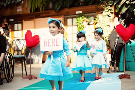 Flower girls carrying sign.