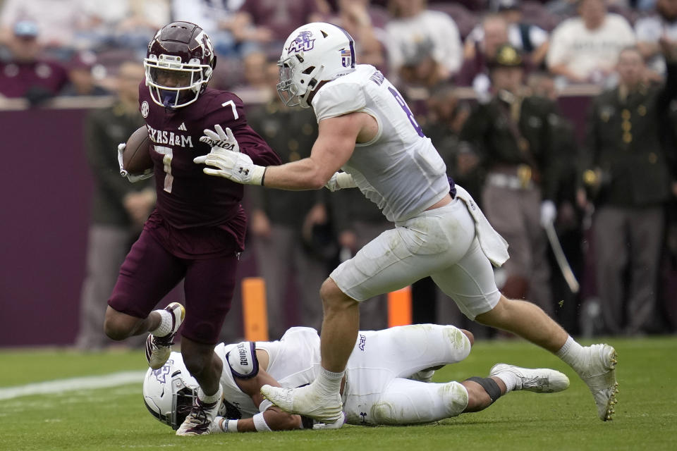 Texas A&M wide receiver Moose Muhammad III (7) tries to fight off Abilene Christian linebacker Kenton Wilhoit (8) during a punt return during the fourth quarter of an NCAA college football game Saturday, Nov. 18, 2023, in College Station, Texas. (AP Photo/Sam Craft)