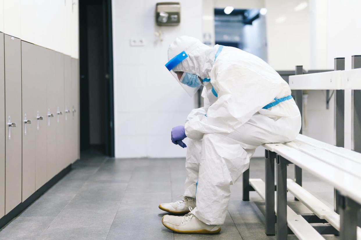 <span class="caption">Many hospitals have reached a point where the demand for health care has outstripped the ability to provide it.</span> <span class="attribution"><a class="link " href="https://www.gettyimages.com/detail/photo/thoughtful-man-wearing-protective-suit-sitting-on-royalty-free-image/1282126173?adppopup=true" rel="nofollow noopener" target="_blank" data-ylk="slk:Westend61 via Getty Images;elm:context_link;itc:0;sec:content-canvas">Westend61 via Getty Images</a></span>