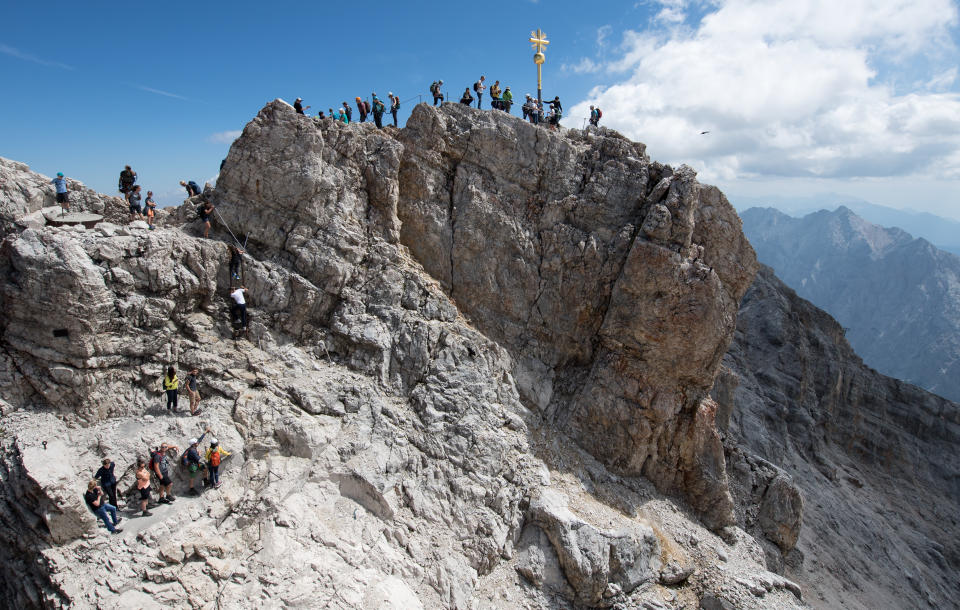 Numerous excursionists use the beautiful weather for an excursion to the summit cross on the Zugspitze.