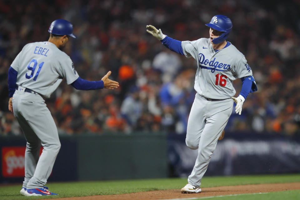 Los Angeles Dodgers' Will Smith (16) is congratulated by third base coach Dino Ebel (91) after hitting a home run against the San Francisco Giants during the eighth inning of Game 2 of a baseball National League Division Series Saturday, Oct. 9, 2021, in San Francisco. (AP Photo/John Hefti)