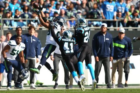 FILE PHOTO - Nov 25, 2018; Charlotte, NC, USA; Seattle Seahawks wide receiver Doug Baldwin (89) attempts to catch a pass against Carolina Panthers defensive back Captain Munnerlyn (41) and cornerback James Bradberry (24) at Bank of America Stadium. Mandatory Credit: Jeremy Brevard-USA TODAY Sports