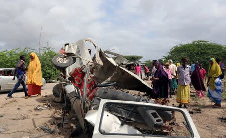 Residents gather to look at the wreckage of a minibus destroyed in roadside bomb in Lafoole village near Somalia's capital Mogadishu, June 30, 2016. REUTERS/Feisal Omar