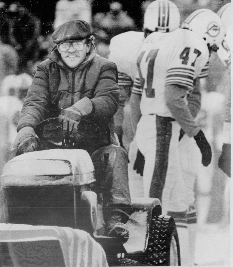 Mark Henderson, left, drives a vehicle that clears snow from the artificial turf at Schaefer Stadium in Foxborough during the game between the New England Patriots and the Miami Dolphins on Dec. 12, 1982. Henderson, who was serving a sentence for burglary at Norfolk prison, cleared snow from the path of New England placekicker John Smith just before Smith booted the winning field goal in New England's 3-0 victory.