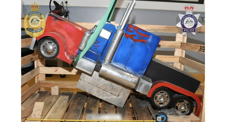 The red and blue model truck sitting in a wooden box. It allegedly contains 35 kilos of heroin.