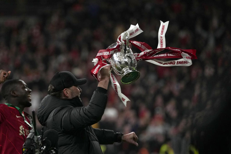 Liverpool's manager Jurgen Klopp celebrates with the trophy after winning the English League Cup final soccer match between Chelsea and Liverpool at Wembley stadium in London, Sunday, Feb. 27, 2022. Liverpool won a penalty shootout 11-10 after the match ended tied 0-0. (AP Photo/Alastair Grant)