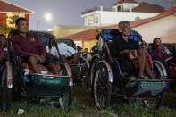 Tricycle drivers attend an outdoor movie screening held by a NGO in Phnom Penh