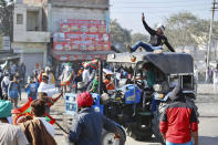 A farmer drives a tractor into a barricade in an attempt to remove it, at the border between Delhi and Haryana state, Friday, Nov. 27, 2020. Thousands of agitating farmers in India faced tear gas and baton charge from police on Friday after they resumed their march to the capital against new farming laws that they fear will give more power to corporations and reduce their earnings. While trying to march towards New Delhi, the farmers, using their tractors, cleared concrete blockades, walls of shipping containers and horizontally parked trucks after police had set them up as barricades and dug trenches on highways to block roads leading to the capital. (AP Photo/Manish Swarup)