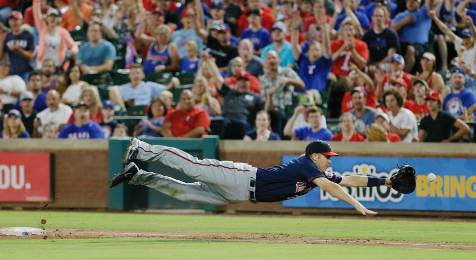 FILE - In this Saturday, July 9, 2016, file photo, Minnesota Twins first baseman Joe Mauer dives for a bad throw from second baseman Brian Dozier during the second inning of a baseball game against the Texas Rangers in Arlington, Texas. The Minneapolis Star Tribune reports that Mauer has taken out an ad in its Sunday, Nov. 11, 2018, paper to announce his retirement. (AP Photo/Brandon Wade, File)