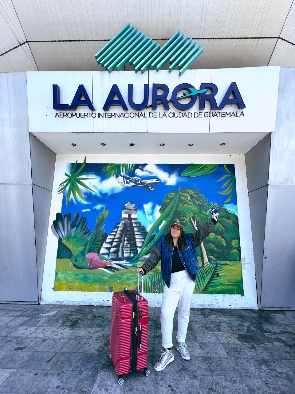 isabella rolz in front of la aurora airport with suitcase in front of her
