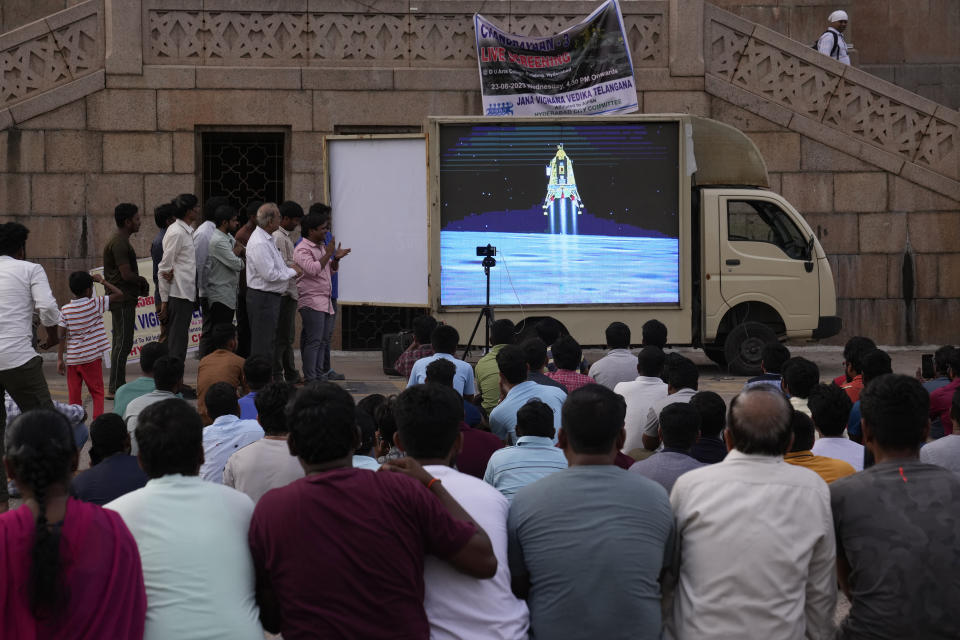 People watch the landing of Chandrayaan-3, or "moon craft" at Omani University in Hyderabad, India, Wednesday, Aug. 23, 2023. India has landed a spacecraft near the moon's south pole, an unchartered territory that scientists believe could hold vital reserves of frozen water and precious elements, as the country cements its growing prowess in space and technology. (AP Photo/Mahesh Kumar A.)