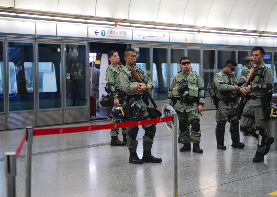 Riot police stand guard at airport express central station in downtown Hong Kong, Saturday, Sept. 7, 2019. Hong Kong authorities were limiting airport transport services and controlling access to terminals Saturday as they braced for a second weekend of disruption following overnight demonstrations that turned violent. (AP Photo/Vincent Yu)