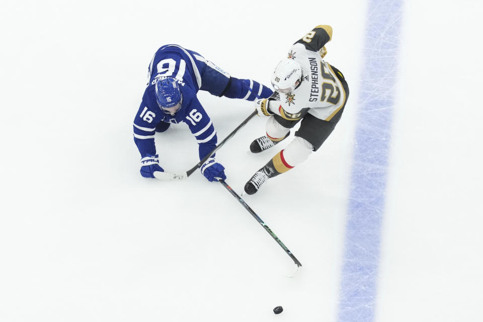 Toronto Maple Leafs' Mitchell Marner (16) and Vegas Golden Knights' Chandler Stephenson (20) go after the puck during the third period of an NHL hockey game in Toronto, on Tuesday, Feb. 27, 2024. (Chris Young/The Canadian Press via AP)