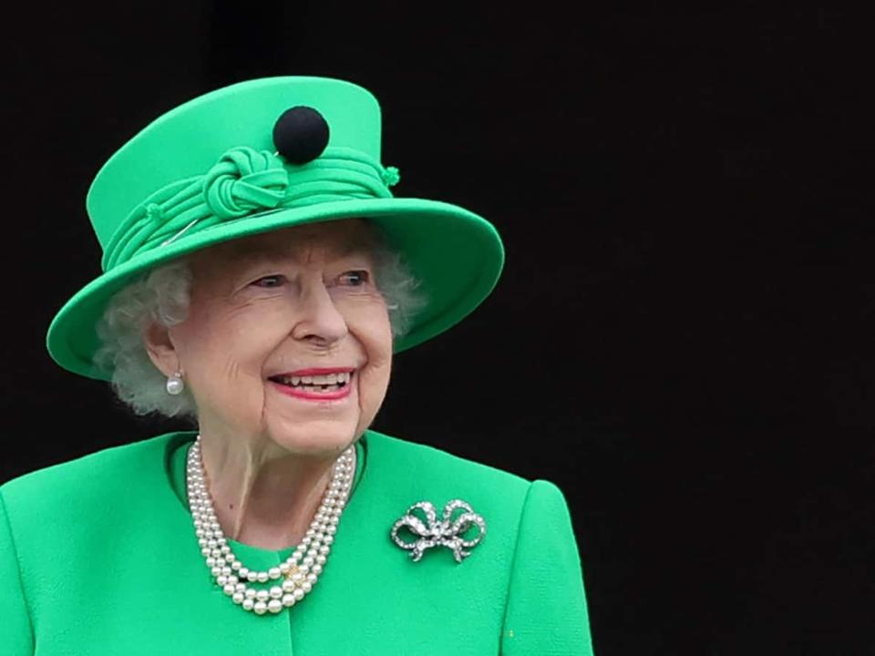 The late Queen Elizabeth smiles to the crowd from Buckingham Palace balcony at the end of the Platinum Pageant in London in June. Federal and provincial governments have yet to decide whether they will declare the day of her funeral, Sept. 19, a national holiday. (Chris Jackson/AFP/Getty Images - image credit)