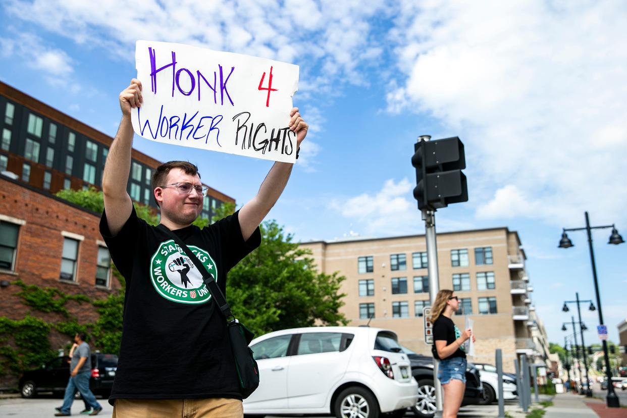 A Starbucks employees holds a sign reading "Honk 4 worker rights" as they stirke, Friday, June 30, 2023, outside the 228 S Clinton St. location in Iowa City, Iowa. The employees voted 25-0 in favor of unionizing out of 30 people eligible in the election on May 11.