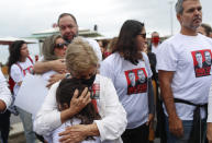 Maria Lucia Farias Sampaio, mother-in-law of British journalist Dom Phillips, embraces a girl during a protest following the disappearance, in the Amazon, of Phillips and expert on indigenous affairs Bruno Araujo Pereira, in Copacabana beach, Rio de Janeiro, Brazil, Sunday, June 12, 2022. Federal Police and military forces are carrying out searches and investigations into the disappearance of Phillips and Pereira in the Javari Valley Indigenous territory, a remote area of the Amazon rainforest in Atalaia do Norte, Amazonas state. (AP Photo/Bruna Prado)