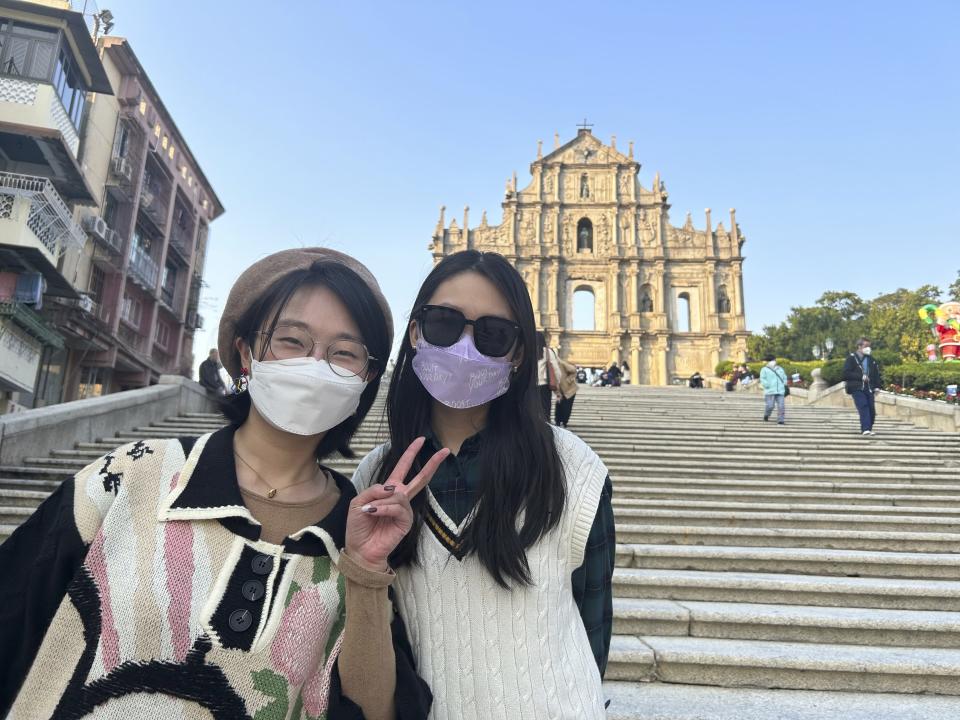 Beijing tourists Xylia Zhang, left, and Charline Zeng pose for a photo as they visit Macao for a five-day trip in Macao on Dec. 28, 2022. Zhang, taking her first trip outside the mainland since the pandemic began, was looking forward to trying her luck in the casinos. (AP Photo/Kanis Leung)