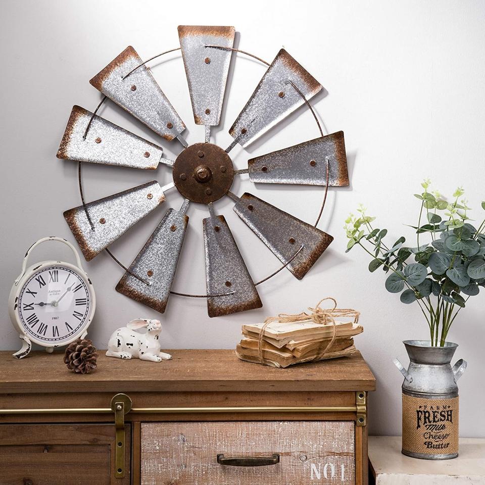 If you're not into the now <a href="https://www.vox.com/the-goods/2020/4/27/21232688/sunburst-mirror-gold-diy-rattan" target="_blank" rel="noopener noreferrer">ubiquitous sunburst mirrors</a>, you might go for this windmill wall hanging that looks handmade. <a href="https://amzn.to/35dggFF" target="_blank" rel="noopener noreferrer">Find it for $36 at Amazon</a>.