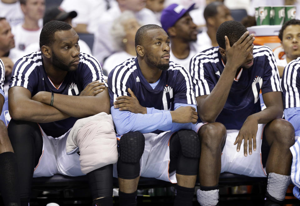 Charlotte Bobcats players, from left, Al Jefferson, Kemba Walker, and Michael Kidd-Gilchrist watch from the bench during the second half in Game 3 of an opening-round NBA basketball playoff series against the Miami Heat in Charlotte, N.C., Saturday, April 26, 2014. The Heat won 98-85. (AP Photo/Chuck Burton)