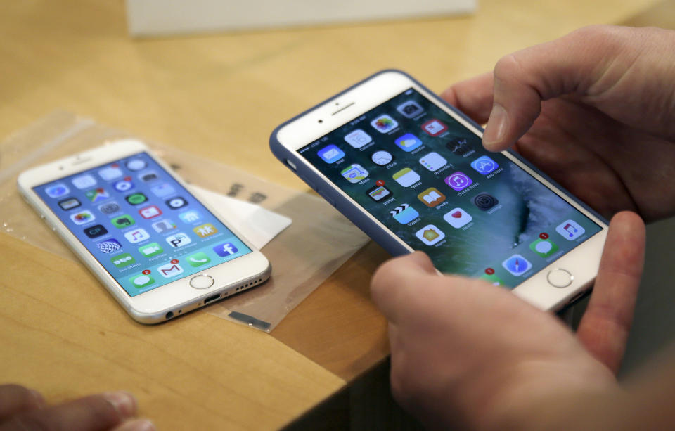 FILE - In this Friday, Sept. 16, 2016, file photo, a customer sets up his new iPhone 7 Plus, right, as he switches from the iPhone 6 at the Apple Store on Michigan Avenue during the release of the Apple iPhone 7 and the latest Apple Watches, in Chicago. New documents from WikiLeaks, posted Thursday, March 23, 2017, point to an apparent CIA program to hack Apple’s iPhones and Mac computers such that the exploits persist even after the devices are reset to factory conditions. Apple says the purported hacking techniques have all been fixed in recent iPhones and Mac computers. (AP Photo/Kiichiro Sato, File)