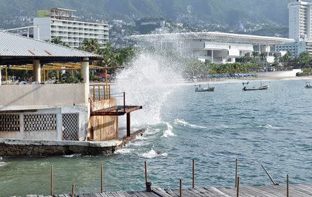 Waves pound the beach in Acapulco as Hurricane Odile churns far off shore September 14, 2014. (REUTERS/Claudio Vargas)