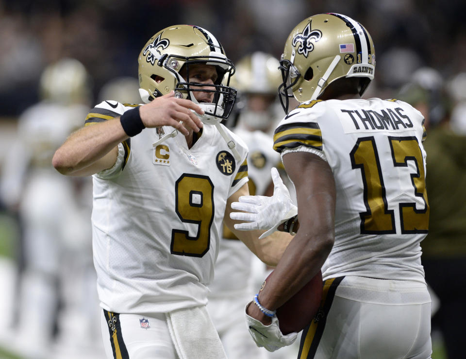 El quarterback de los Saints de Nueva Orleans, Drew Brees (9) celebra su pase de touchdown con el wide receiver Michael Thomas (13) durante la segunda mitad del juego contra los Eagles de Filadelfia, el domingo 18 de noviembre de 2018, en Nueva Orleans. (AP Foto/Bill Feig)