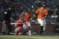 San Francisco Giants' Brandon Belt (9) watches his solo home run in front of Philadelphia Phillies catcher Andrew Knapp during the fifth inning of a baseball game Friday, June 18, 2021, in San Francisco. (AP Photo/Tony Avelar)