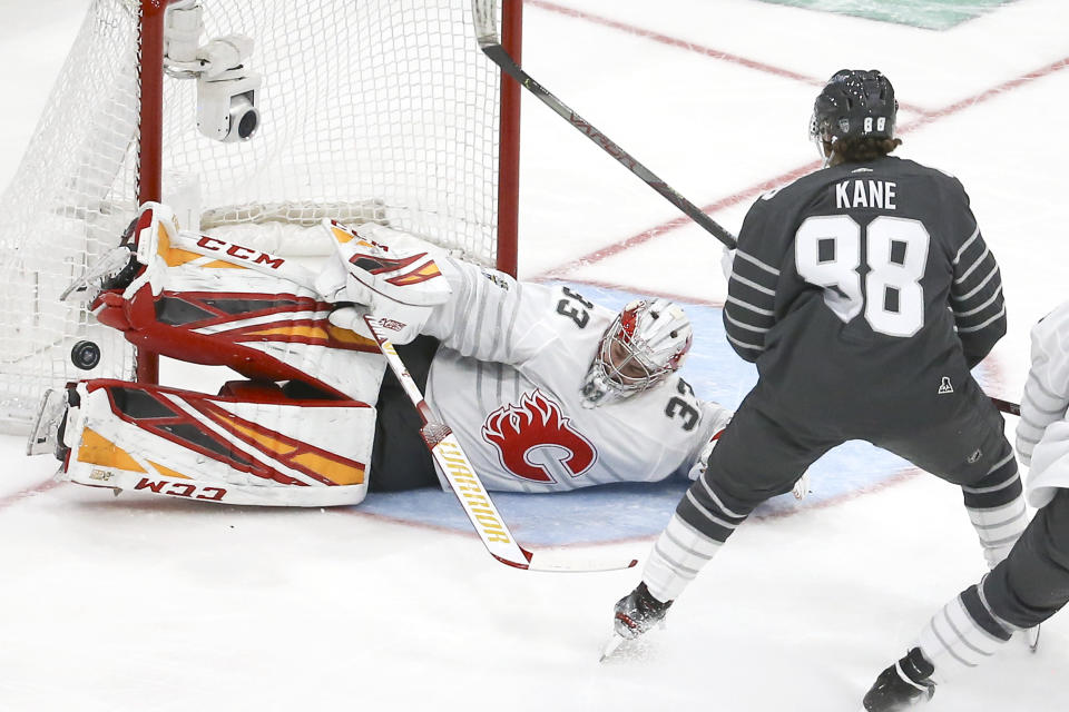 Calgary Flames goalie David Rittich (33) blocks a shot against Chicago Blackhawks forward Patrick Kane (88) during an NHL All-Star semifinal game, Saturday, Jan. 25, 2020, in St. Louis. (AP Photo/Scott Kane)