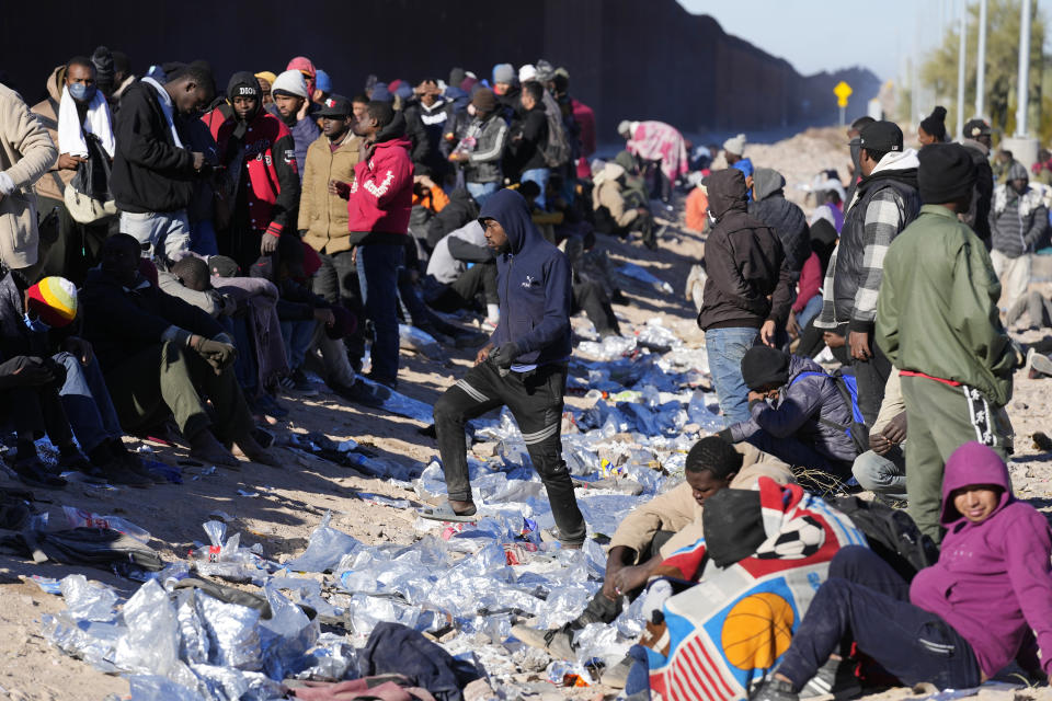 Hundreds of migrants, mostly from African countries, gather along the border waiting to be brought into custody after breaking through gaps in the border wall Tuesday, Dec. 5, 2023, in Lukeville, Ariz. The U.S. Border Patrol says it is overwhelmed by a shift in human smuggling routes, with hundreds of migrants from faraway countries like Senegal, Bangladesh and China being dropped in the remote desert area in Arizona. (AP Photo/Ross D. Franklin)