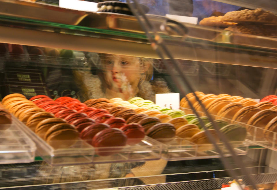 This Dec. 5, 2013 photo shows young girl looking at macarons at Bouchon Bakery, in New York's Rockefeller Center. Rockefeller Center is crowded at Christmastime thanks to the famous tree, the skating rink and the show at Radio City Music Hall, but visitors can choose from a variety of places to eat in the area, from ethnic food and street carts to sit-down dining. (AP Photo/Richard Drew)