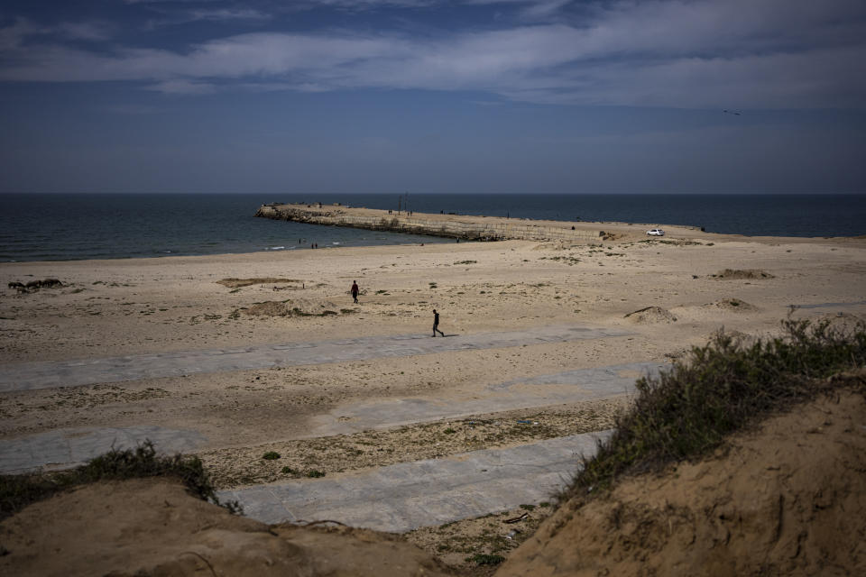 Palestinians walk by a pier that could be used to bring humanitarian aid to the Gaza Strip in Khan Younis on Wednesday, March 13, 2024. (AP Photo/Fatima Shbair)