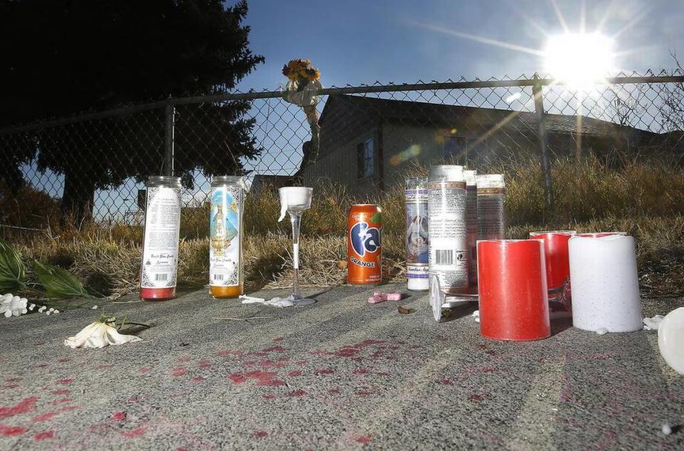A memorial of candles, flowers and a can of soda for murder victim Hunter Black, 18, is set on the sidewalk outside the fence of the home at 401 S. Yelm St. in Kennewick.