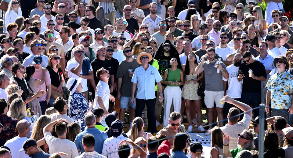 A crowd watches a two-up game.