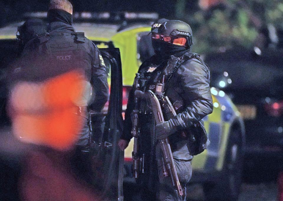 An armed police officer holds a breaching shotgun, used to blast the hinges off a door, at an address in Rutland Avenue in Sefton Park (PA)