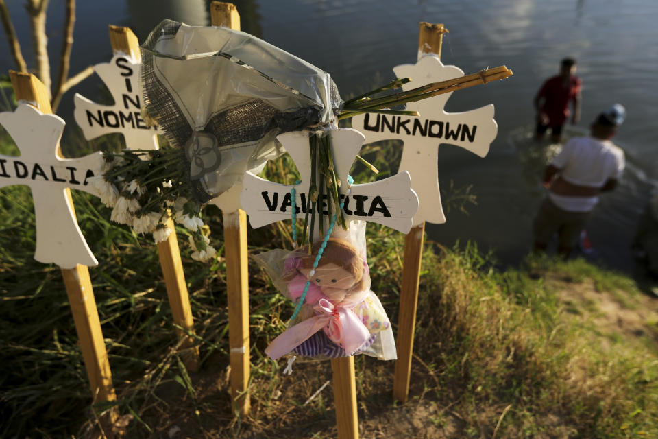 In this Oct. 11, 2019 photo, crosses covered with the names of people who have drowned trying to cross the river stand on the bank of the Rio Grande in Matamoros, Mexico. Migrants who make it this far, tell stories of being captured by armed bandits who demand a ransom: They can pay for illegal passage to the border, or merely for their freedom, but either way they must pay. (AP Photo/Fernando Llano)