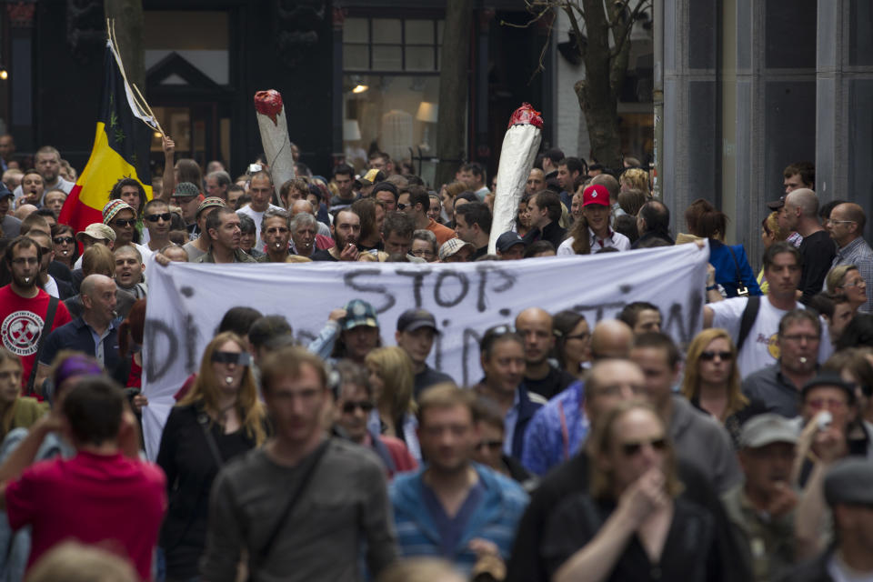 Two larger-than-life marijuana joints tower over a protest rally against the new marijuana buying policy in Maastricht, southern Netherlands, Tuesday May 1, 2012. A policy barring foreign tourists from buying marijuana in the Netherlands goes into effect in parts of the country Tuesday, with a protest planned in the southern city of Maastricht. Weed is technically illegal in the Netherlands, but it is sold openly in small amounts in designated cafes under the country's famed tolerance policy. The government has said that as of May 1, only holders of a "weed pass" will be allowed to purchase the drug, and nonresidents aren't eligible. (AP Photo/Peter Dejong)