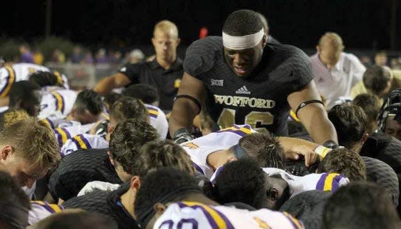 Wofford player John Patterson leads prayer for teammate Michael Roach before play was resumed against Tennessee Tech in a 2016 game.