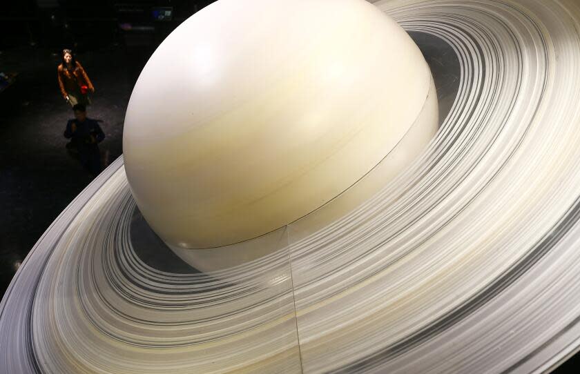 LOS ANGELES, CALIF. - FEB. 18, 2020. Visitors walk through a display of the solar system in the lower level of the Griffith Observatory. (Luis Sinco/Los Angeles Times)