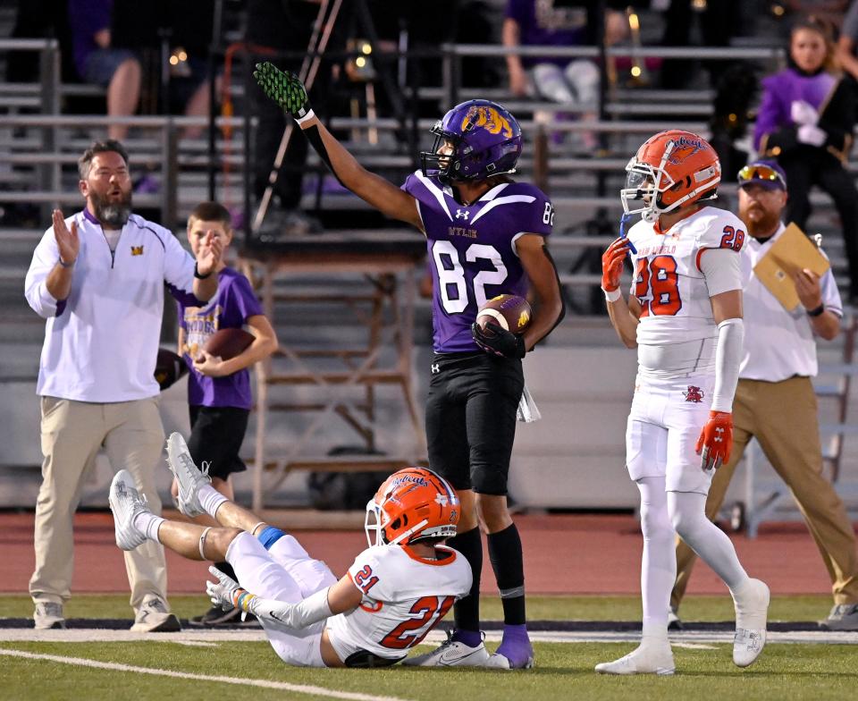 Wylie wide receiver Derrick Evans points toward the goal after successfully catching a pass despite the efforts of San Angelo Central cornerback Kaleb Cobb on the ground in front of him Sept. 22 in Abilene.