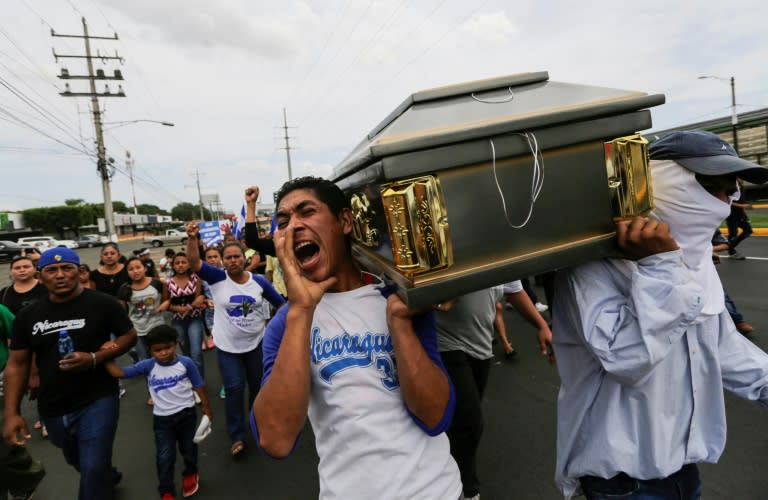 Friends and relatives carry a coffin containing the body of a student shot dead during clashes with riot police in a church near the National Autonomous University of Nicaragua in Managua on July 16, 2018
