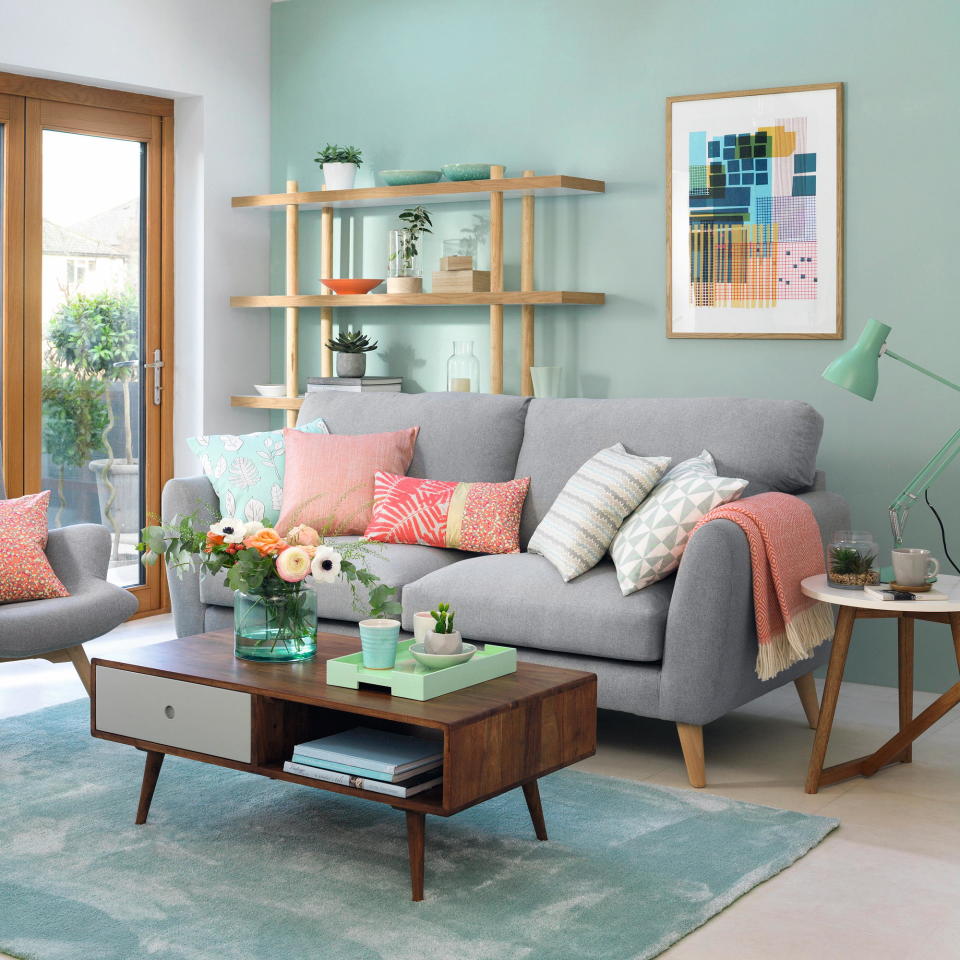 living room with patio doors out to garden, and walls painted mint green and a soft grey sofa