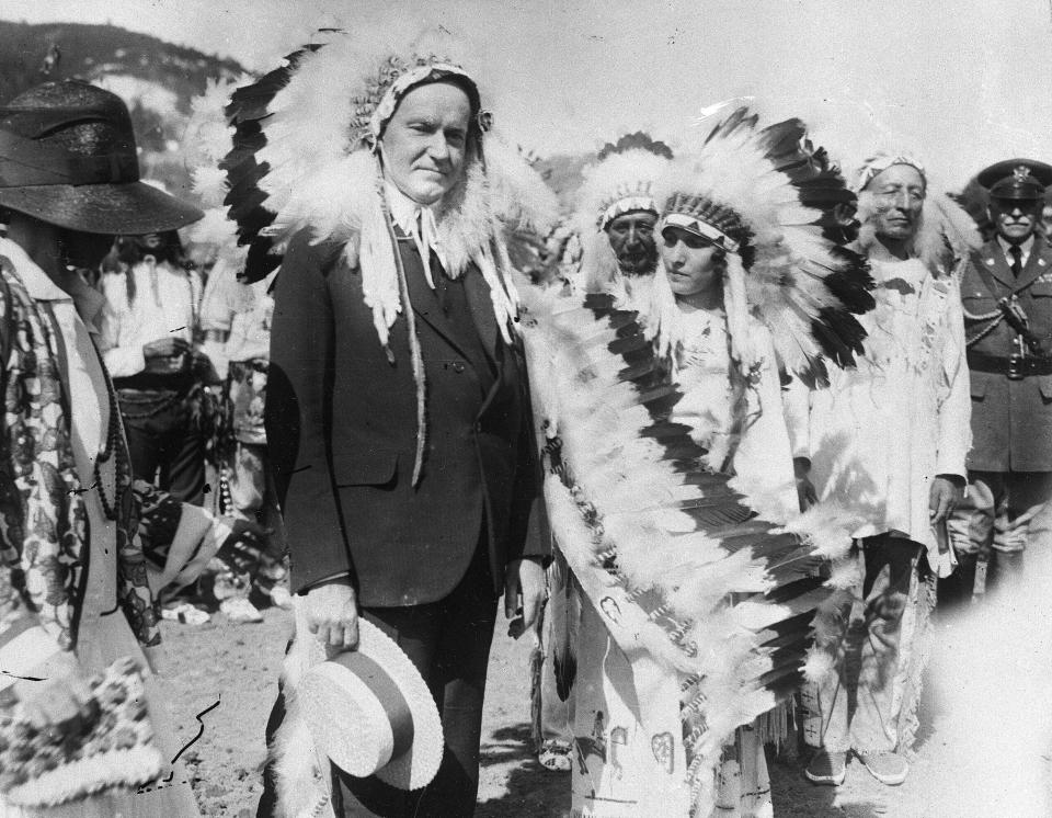 FILE - U.S. President Calvin Coolidge wears a Native American headdress of the Sioux tribe as he is adopted as Chief Leading Eagle and first white chief of the tribe at the celebration of the 51st anniversary of the settlement of Deadwood, South Dakota, in 1927. Coolidge signed the Indian Citizenship Act of 1924. (AP Photo/File)