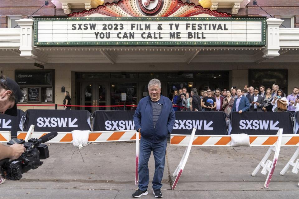 William Shatner stands in front of a marquee highlighting his new documentary 