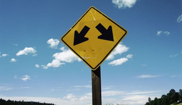 A road sign with two arrows pointing in different directions