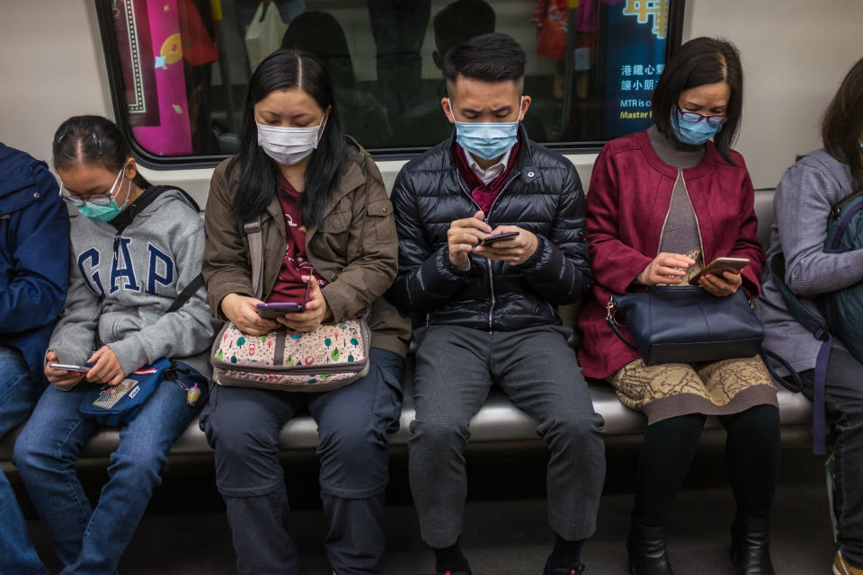 People wear masks on a train on the first day of the Lunar New Year of the Rat in Hong Kong on January 25, 2020, as a preventative measure following a coronavirus outbreak which began in the Chinese city of Wuhan. - Hong Kong on January 25 declared a mystery virus outbreak as an "emergency" -- the city's highest warning tier -- as authorities ramped up measures aimed at reducing the risk of further infections spreading. (Photo by DALE DE LA REY / AFP) (Photo by DALE DE LA REY/AFP via Getty Images)