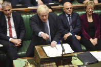 Britain's Prime Minister Boris Johnson speaks to lawmakers inside the House of Commons to update details of his new Brexit deal with EU, in London Saturday Oct. 19, 2019. At a rare weekend sitting of Parliament, Johnson implored legislators to ratify the Brexit deal he struck this week with the other 27 EU leaders. Secretary of State for Exiting the European Union, Stephen Barclay, left, and Business Secretary Andrea Leadsom, right. (Jessica Taylor/House of Commons via AP)
