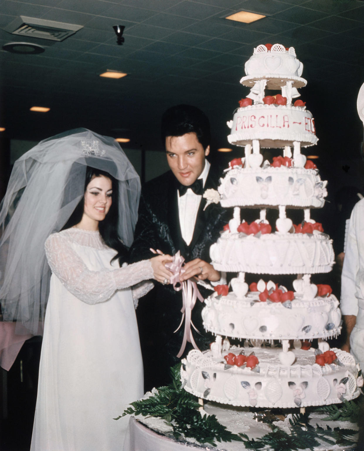 Elvis Presley cuts wedding cake with bride Priscilla Presley in May 1, 1967, in Las Vegas. (Bettmann Archive / Getty Images)